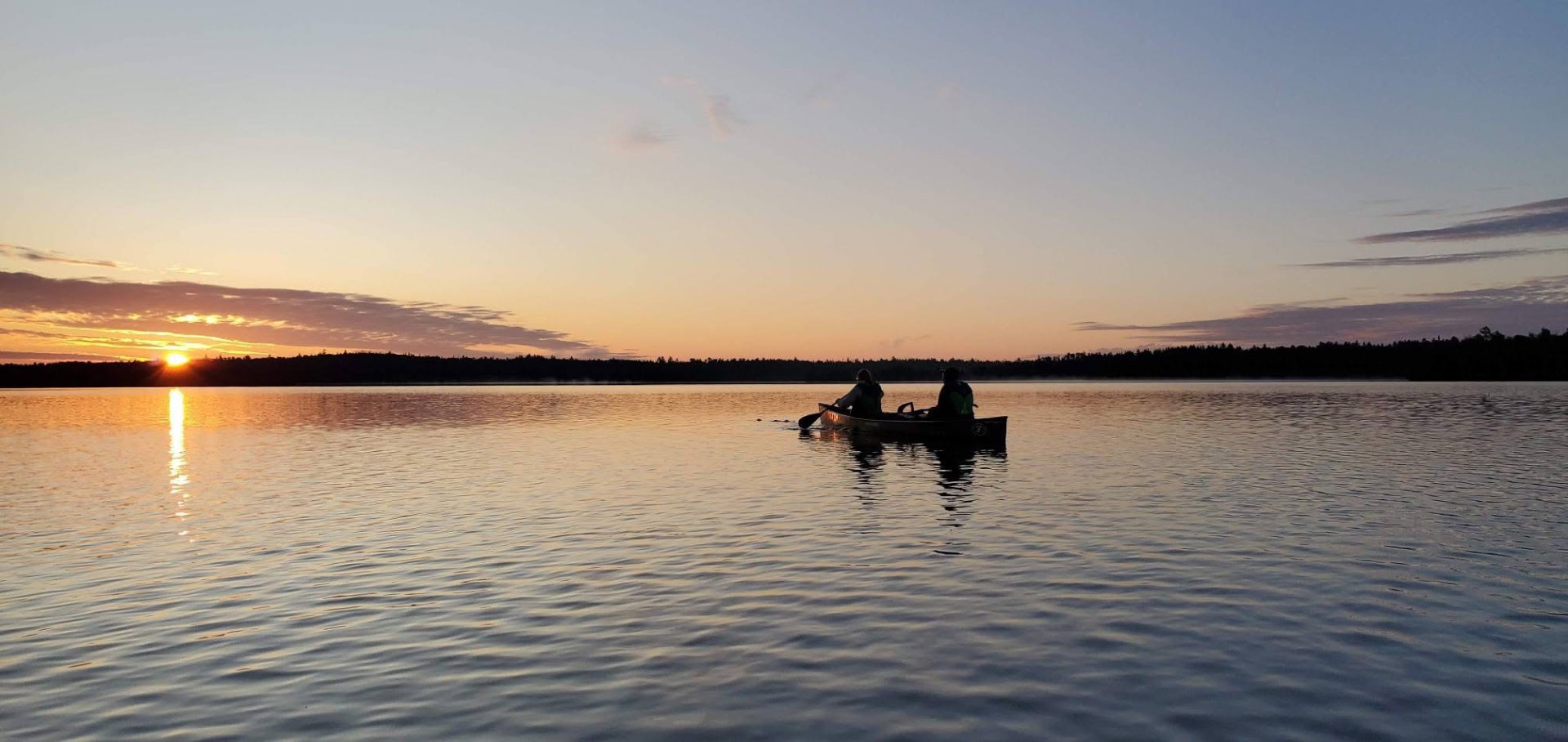 Two young women canoeing at dawn